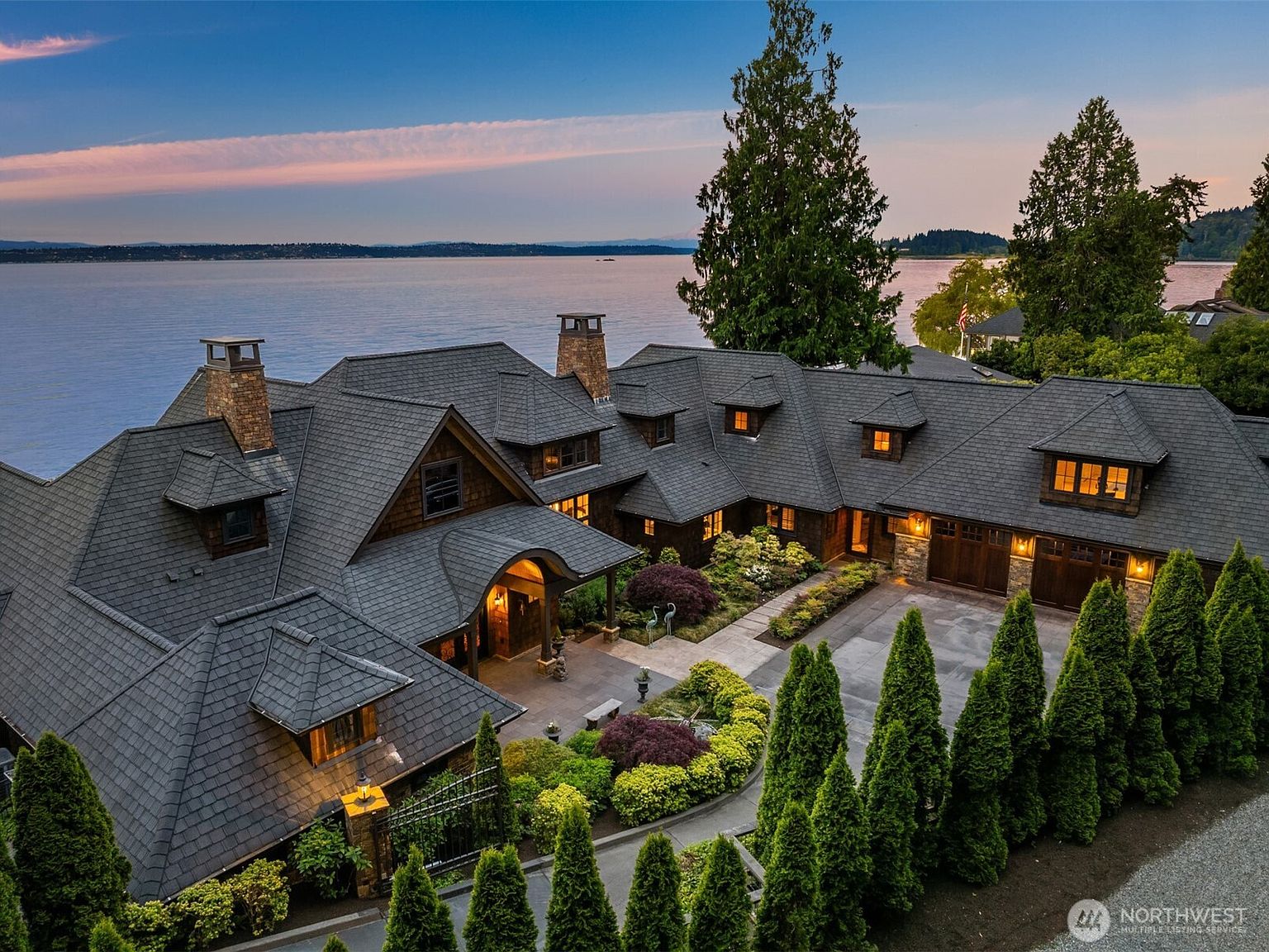 A high study of the cedar-shingle rooflines, dormers, and copper-capped chimneys defining the residence's Pacific Northwest vernacular.